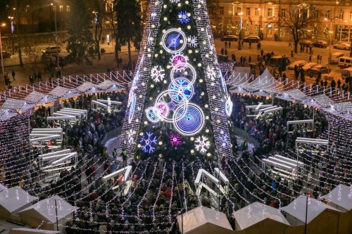 В Вильнюсе установили рождественскую ёлку, украшенную гирляндами длиной более 5 километров. Сверху она похожа на часы (5 фото)