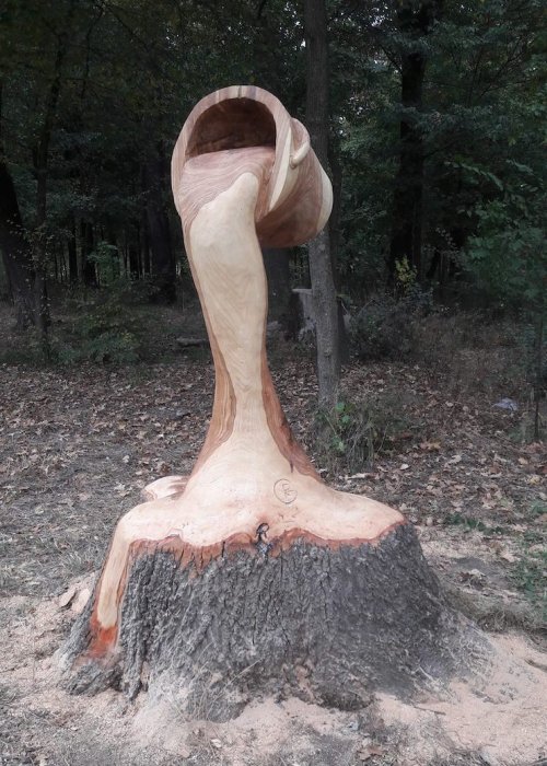 Ведро с льющейся из него водой, вырезанное из дерева бензопилой (7 фото)