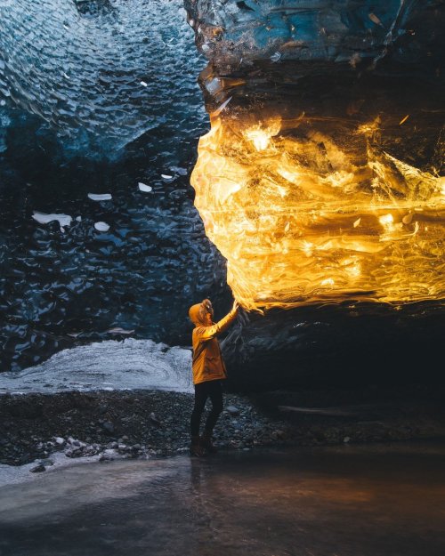 Фотограф запечатлела невероятное янтарное сияние в ледяной пещере в Исландии (8 фото)