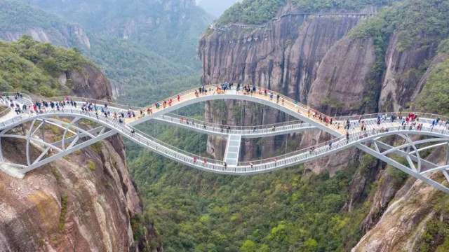 В Китае открылся изогнутый стеклянный мост, построенный на высоте 140 метров (3 фото + видео)