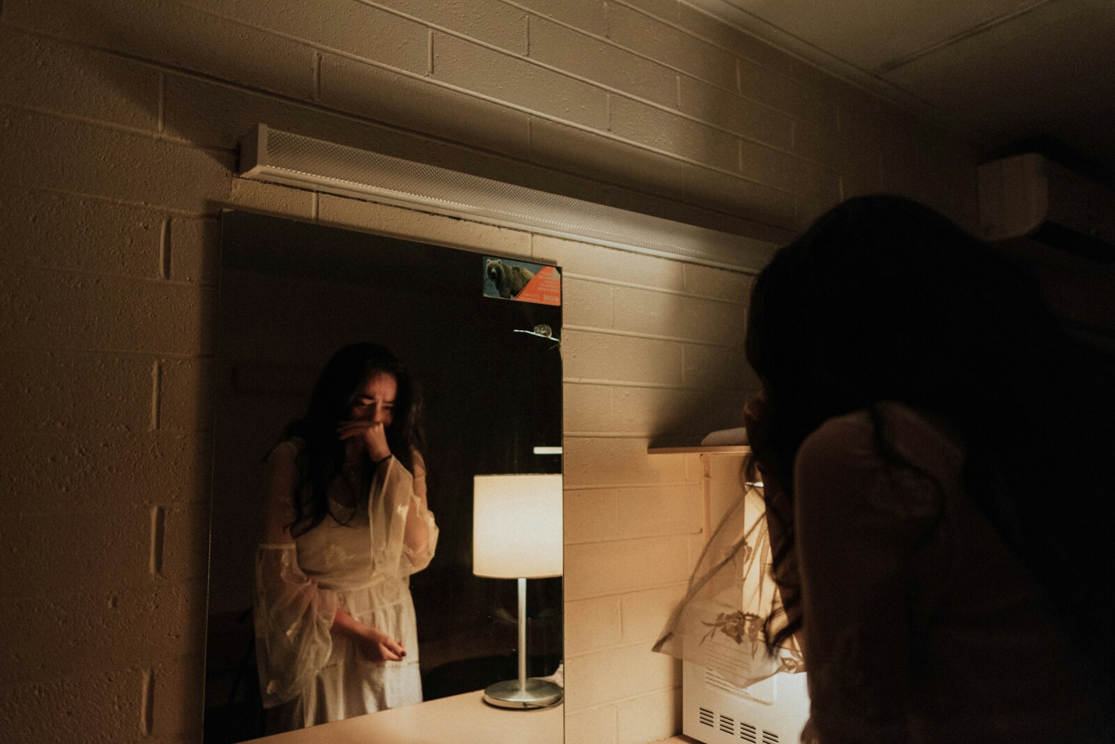 Женщина плачет ночью у зеркала