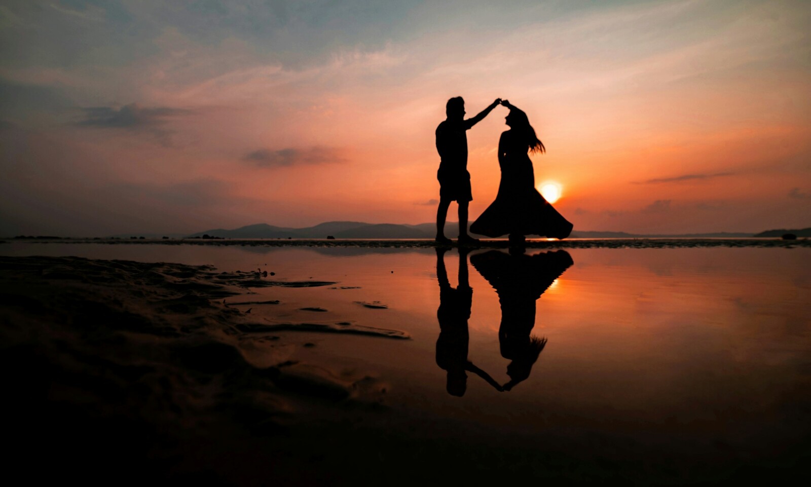супруги танцуют на закате